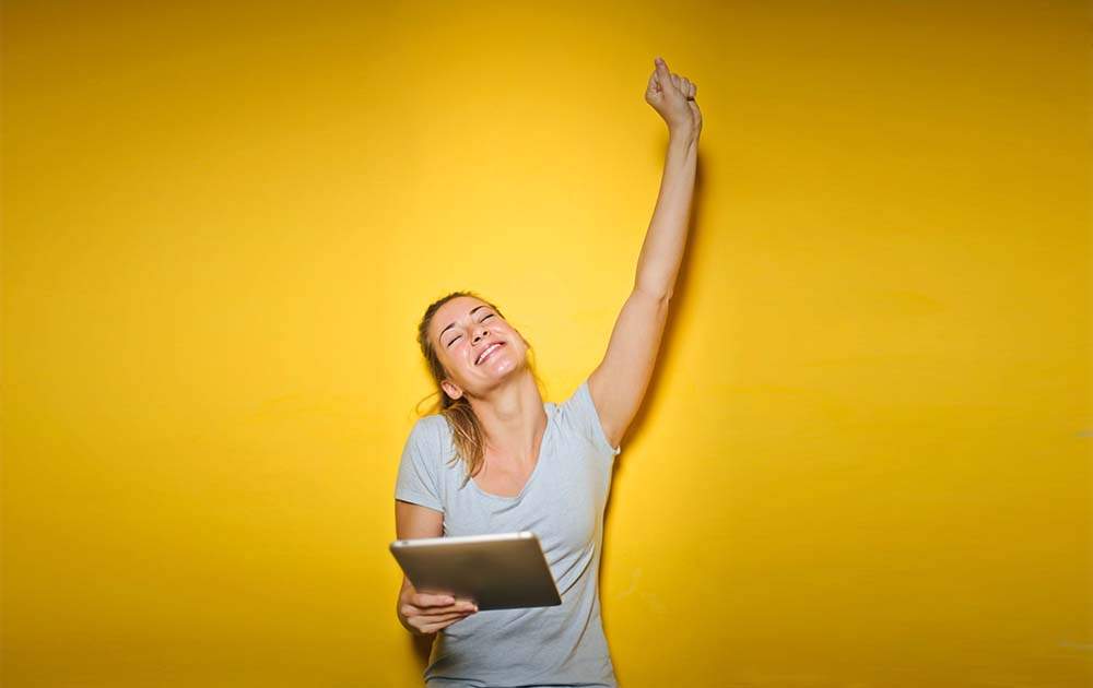 Woman Celebrating with Tablet